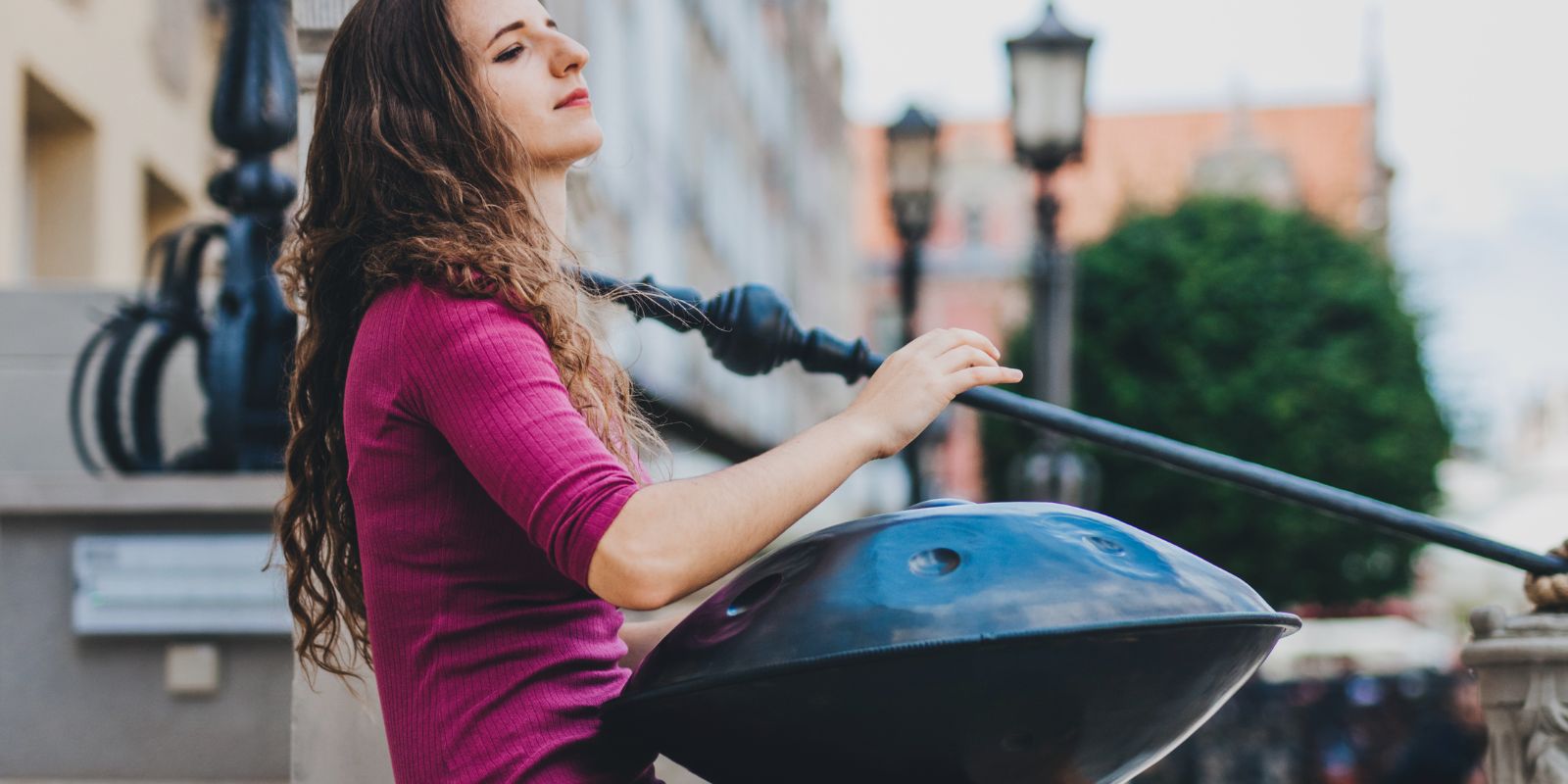 Woman playing a handpan on urban stairs, beginner handpan guide for choosing and buying a handpan in Australia