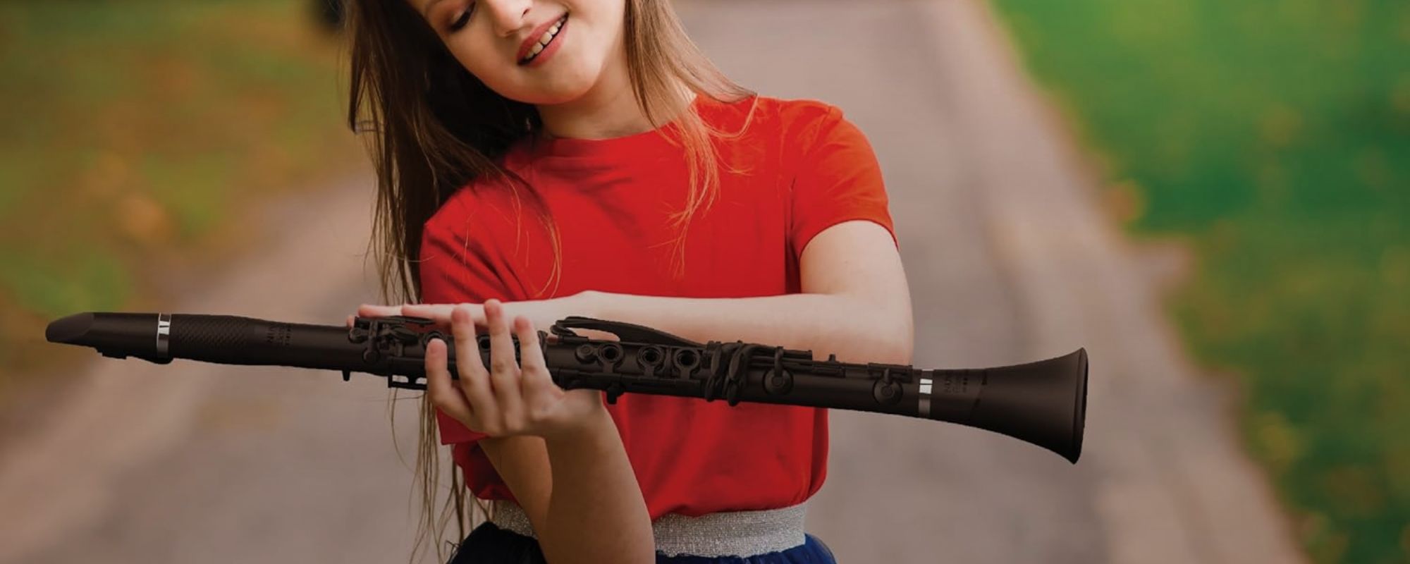 Young student holding a Nuvo Nuvoband clarinet outdoors, highlighting a lightweight modern wind instrument designed for confident classroom learning and beginner play