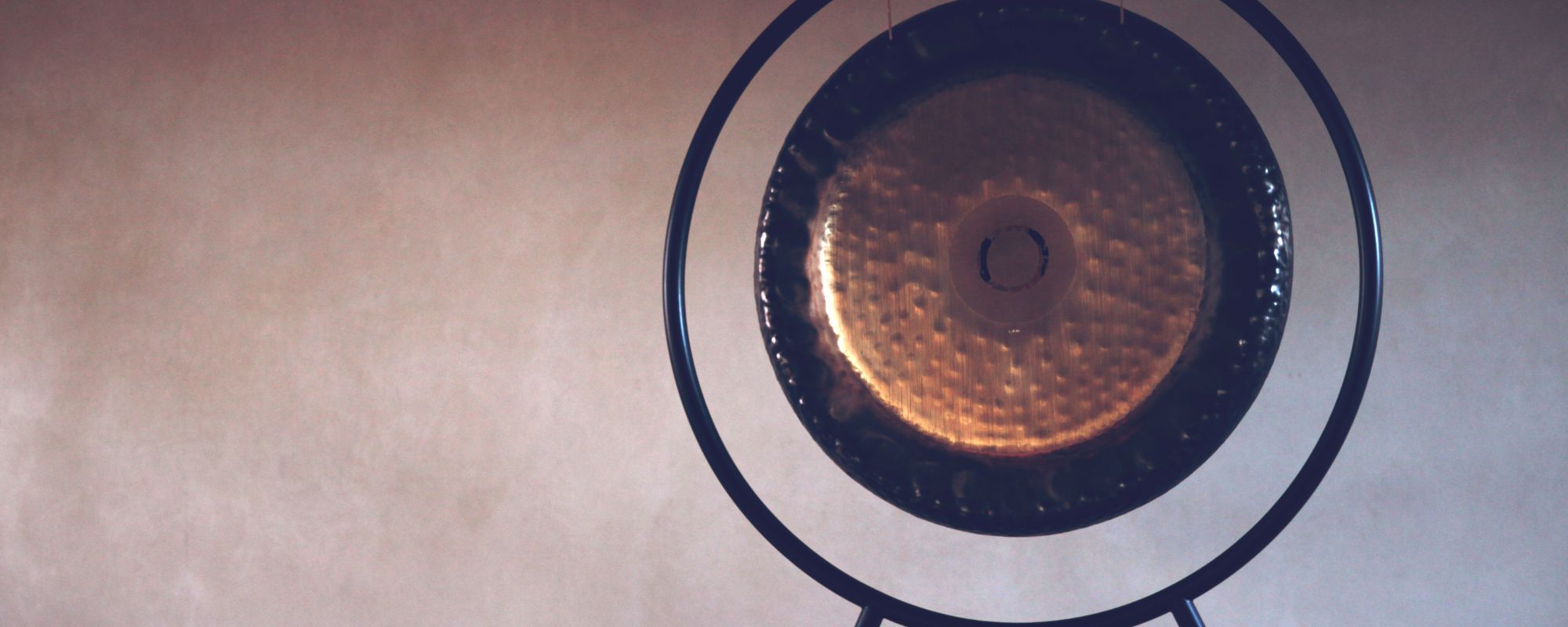 Large gong on a stand with an abstract background, used for immersive sound healing and meditation.