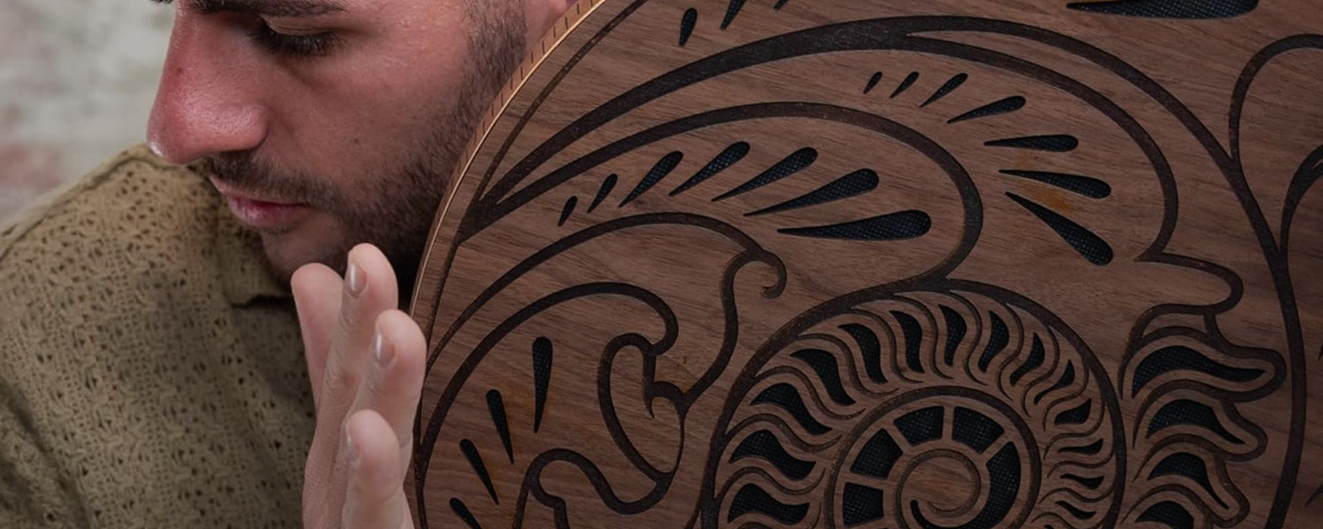 close up of man playing rain disk near face during meditation and sound therapy session showing immersive ambient sound experience