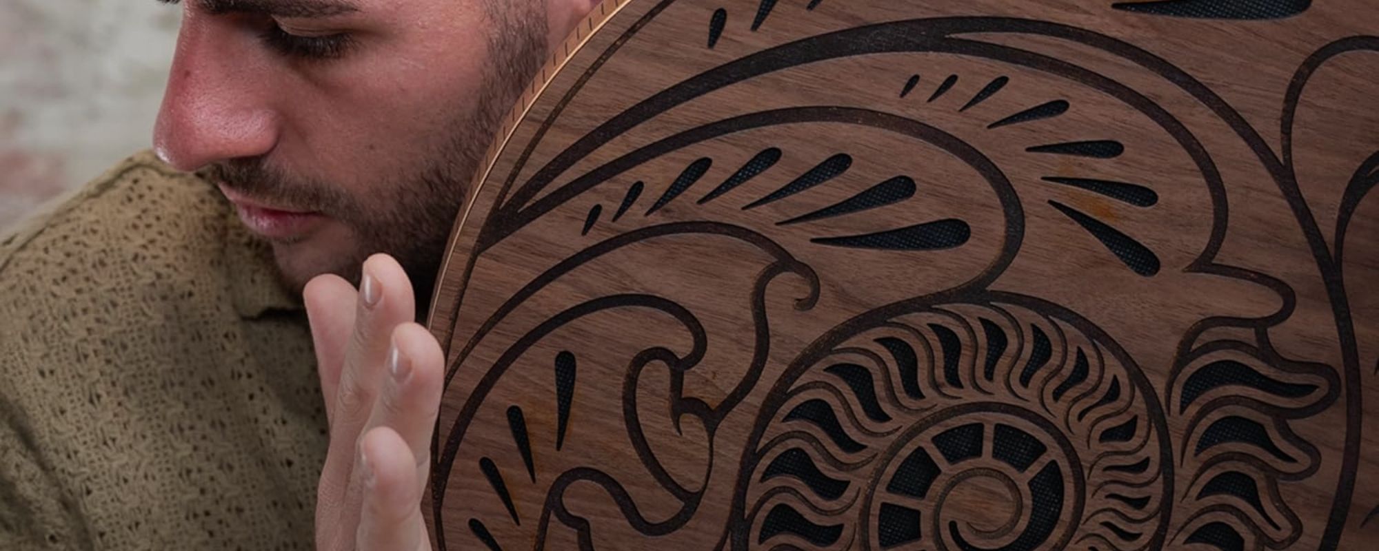 close up of man playing rain disk near face during meditation and sound therapy session showing immersive ambient sound experience