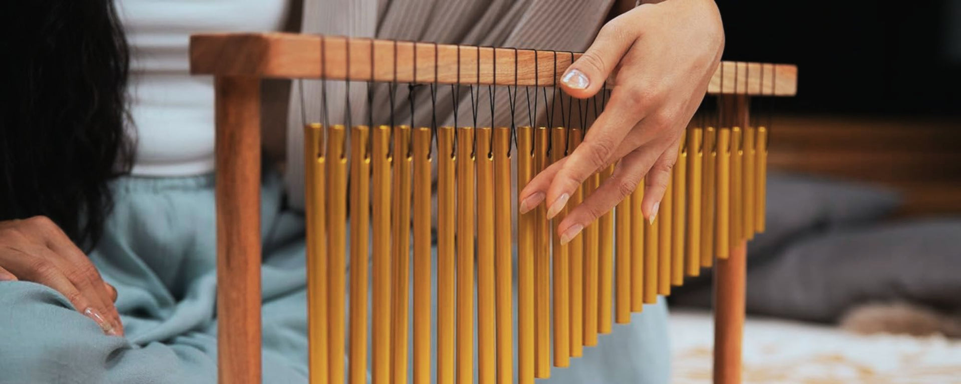 Woman playing table chimes during a relaxing sound therapy session.