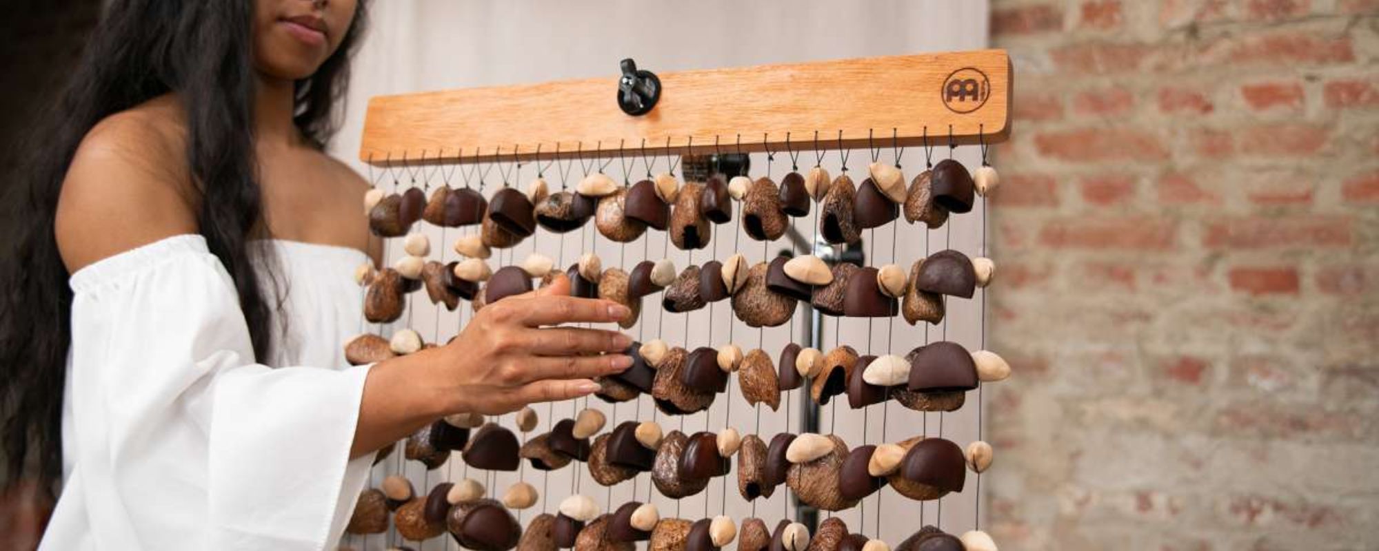 Woman playing wood chimes with mixed seed chimes during a professional sound healing and meditation session