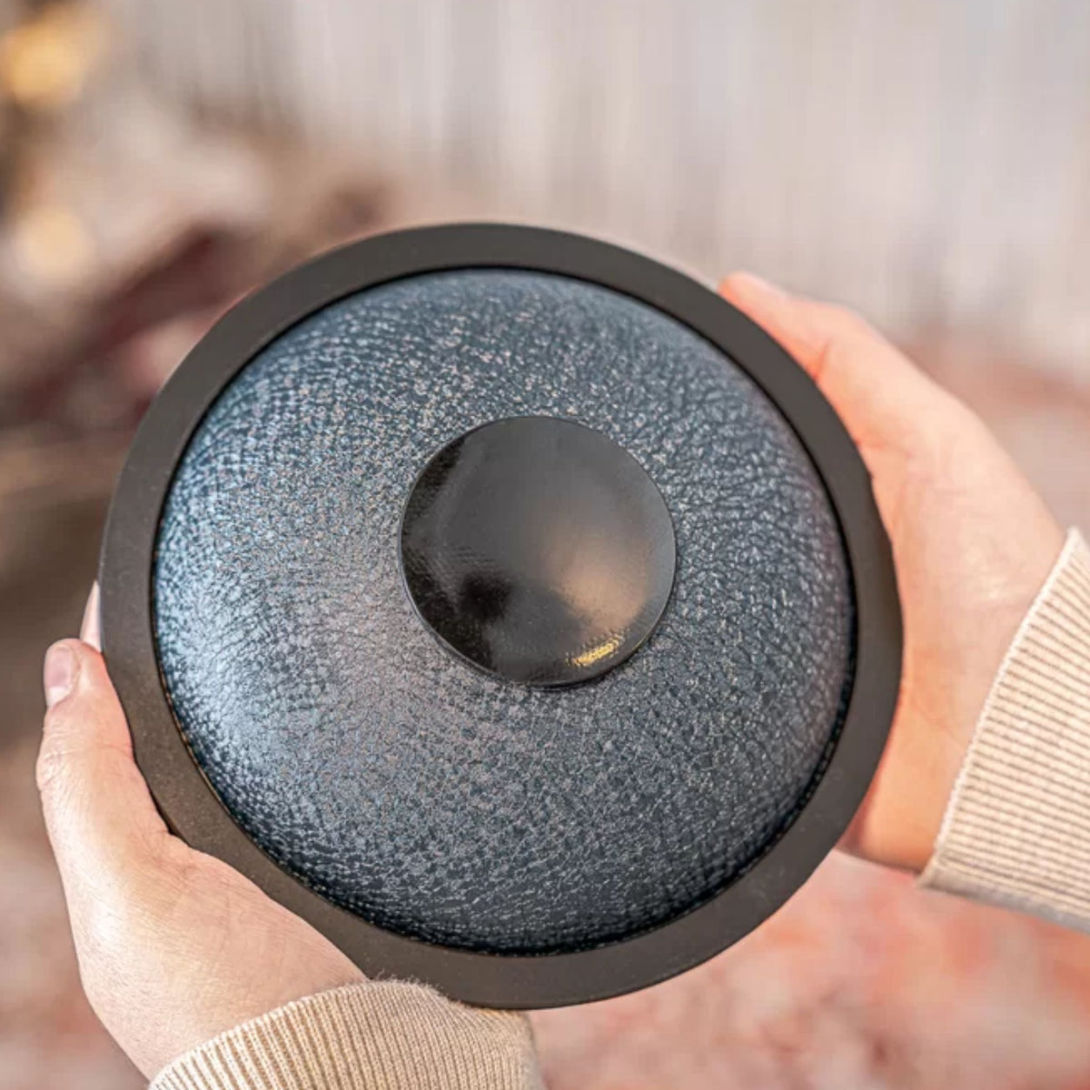 Person showing the bottom of the Meinl Sonic Energy Mini Steel Tongue Drum.