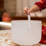 Woman playing a Meinl Sonic Energy crystal singing bowl with a mallet during a sound healing session for meditation and frequency practice