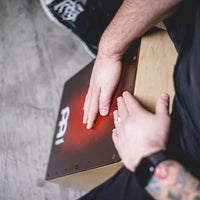 Percussionist playing a Meinl cajon drum at Drum Republic.