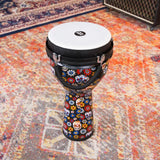 Meinl Jumbo Series Djembe Drum 10" Day of the Dead JD10DA displayed on a patterned rug in a music studio setting.