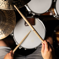 Drummer playing a drum kit with the Meinl Kriss Rybalchenko Signature Drumsticks SB603, demonstrating their balanced feel, speed, and powerful response.