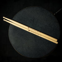 Meinl Kriss Rybalchenko Signature Drumsticks SB603 resting on a drum throne, ready for practice, rehearsal, or live performance.