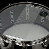 Bottom view of the Tama S.L.P. Black Brass Snare Drum LBR1465 showing the snare-side head, 42-strand carbon steel snare wires, and Black Nickel hoop and hardware.