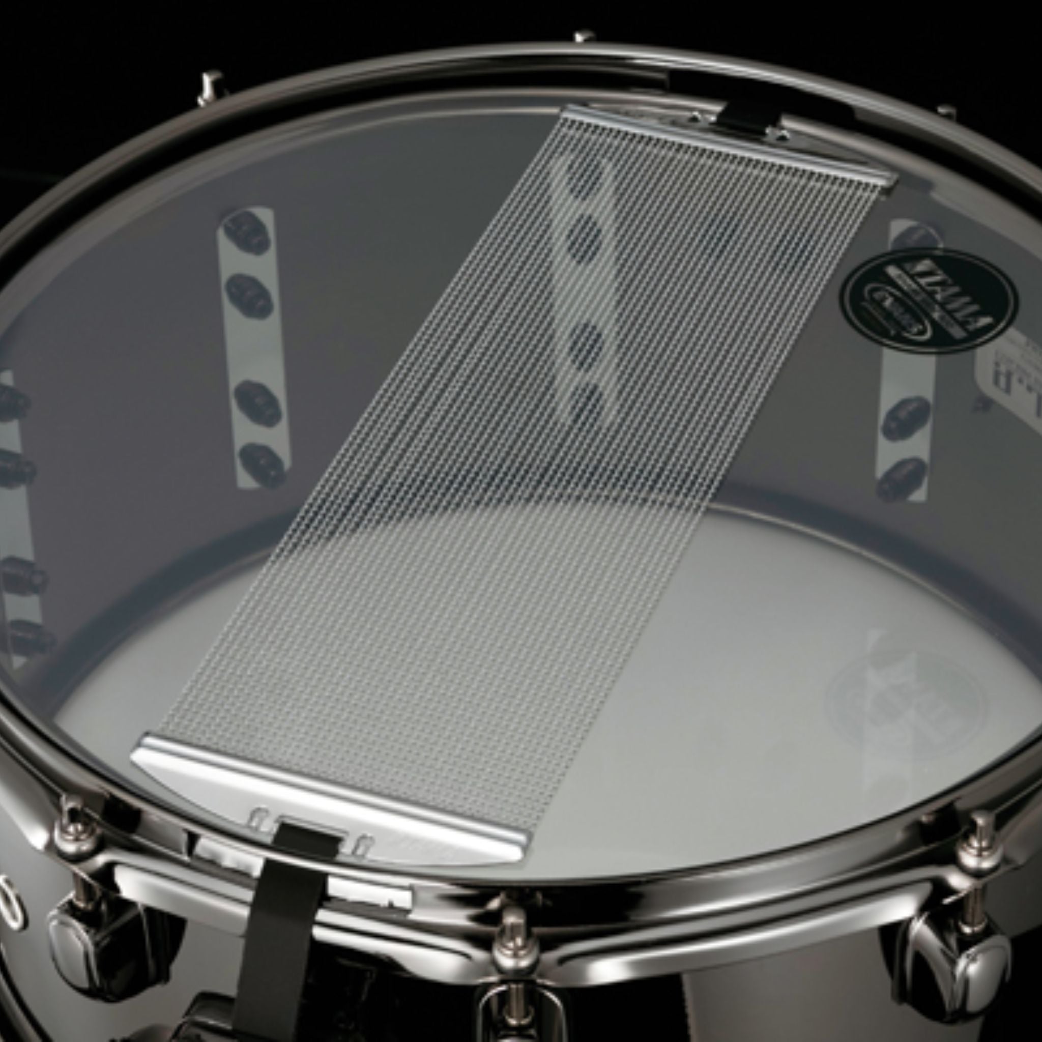 Bottom view of the Tama S.L.P. Black Brass Snare Drum LBR1465 showing the snare-side head, 42-strand carbon steel snare wires, and Black Nickel hoop and hardware.