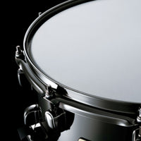 Close-up of the Tama S.L.P. Black Brass Snare Drum LBR1465 showing the snare head, 2.3mm triple-flanged Steel Mighty Hoop, and Black Nickel hardware.