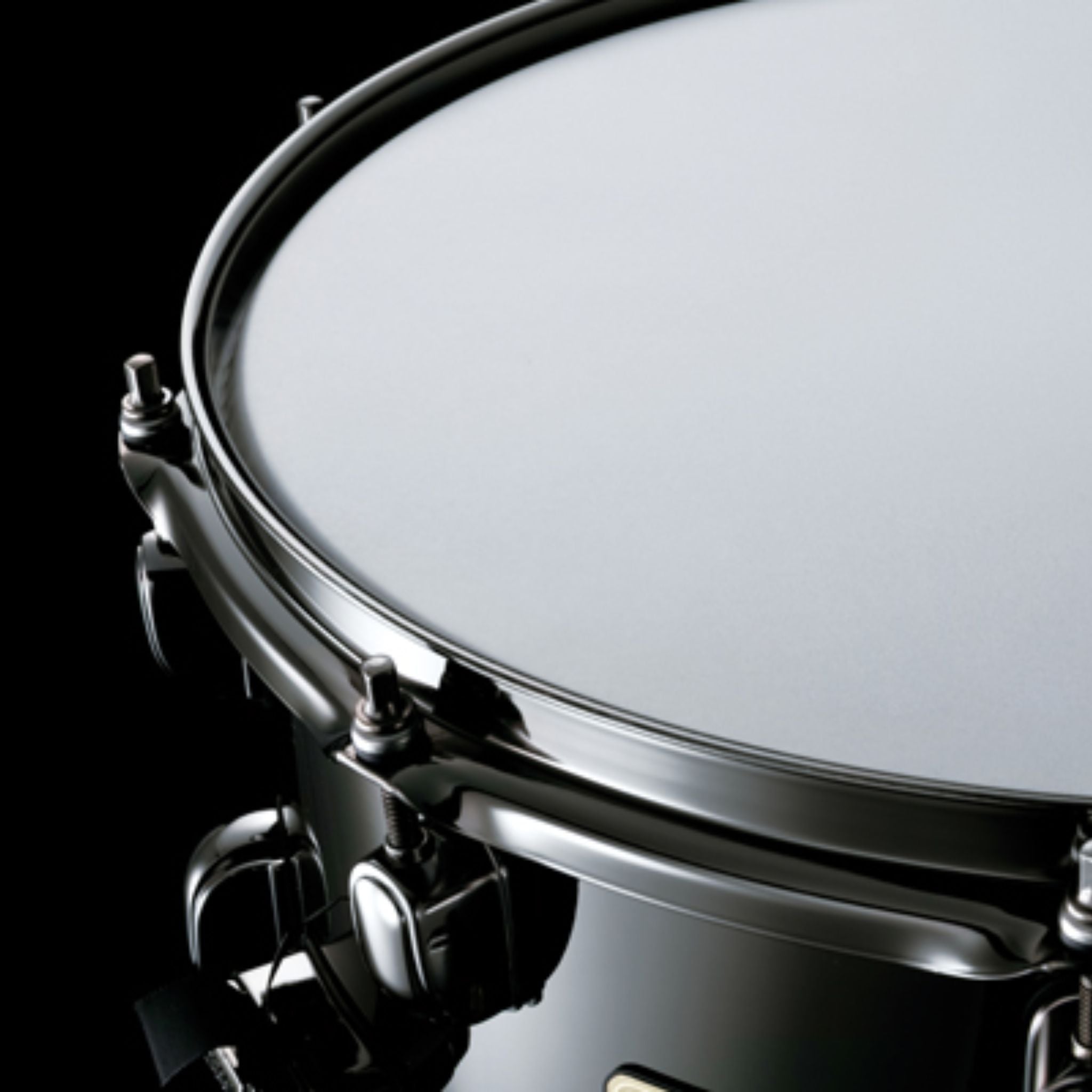 Close-up of the Tama S.L.P. Black Brass Snare Drum LBR1465 showing the snare head, 2.3mm triple-flanged Steel Mighty Hoop, and Black Nickel hardware.
