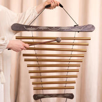 Woman playing a Meinl Sonic Energy meditation flow chime during a sound healing session to create gentle resonant tones for meditation and relaxation