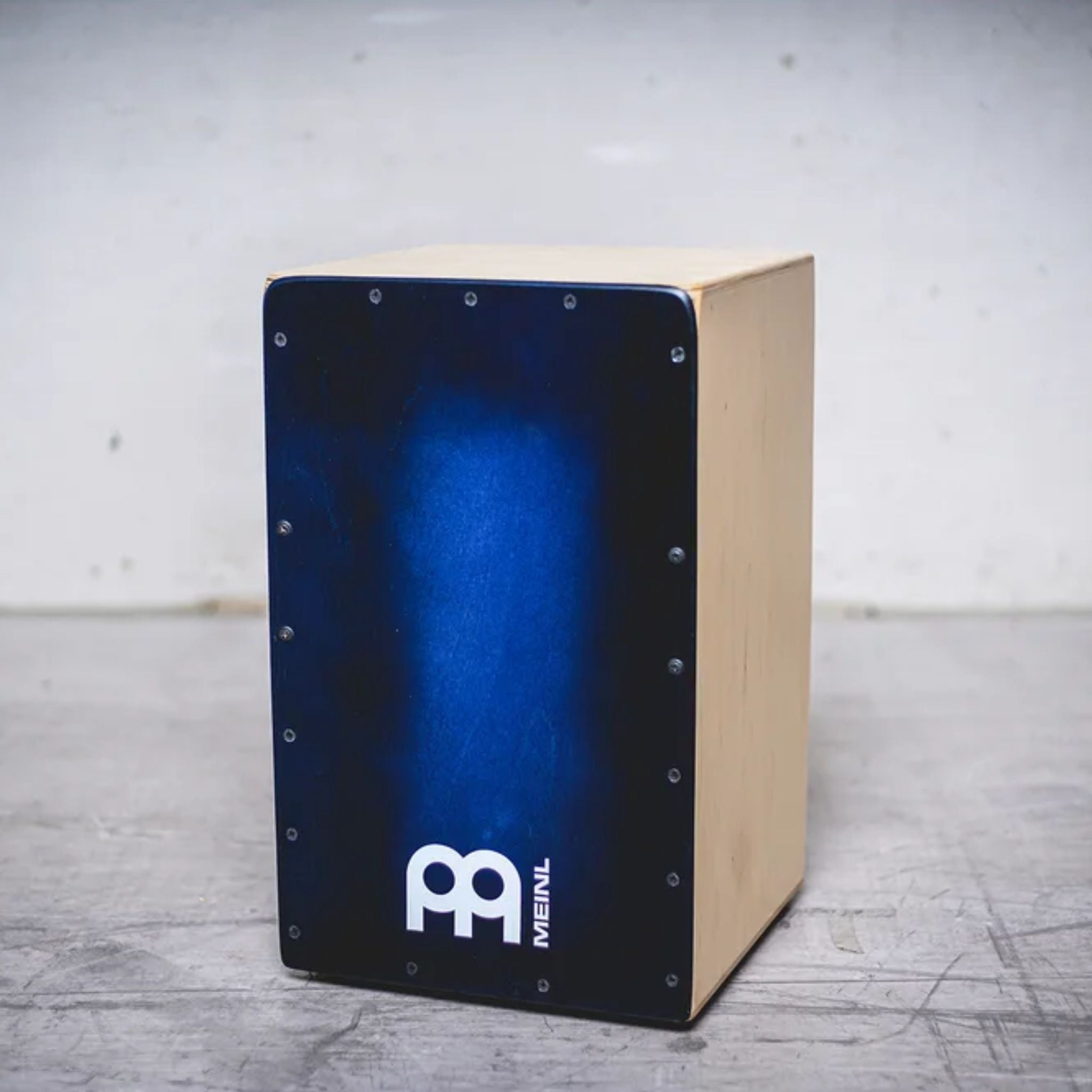 Cajon displayed on studio floor showcasing the Blue Burst design and birch cabinet.