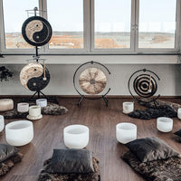 Meinl Sonic Energy Flower of Life Wind Gong on gong stand in meditation space surrounded by singing bowls, cushions, and additional gongs