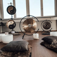 close up of Meinl Sonic Energy Flower of Life Wind Gong on gong stand in meditation space with singing bowls and wellness instruments nearby