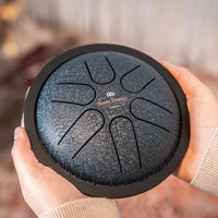 Sound therapist holding the Meinl Sonic Energy Mini Steel Tongue Drum with both hands.