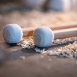 Close-up lifestyle image of the medium felt heads on the Meinl 5A Drum Mallets SB401 displayed on a workbench with sawdust.