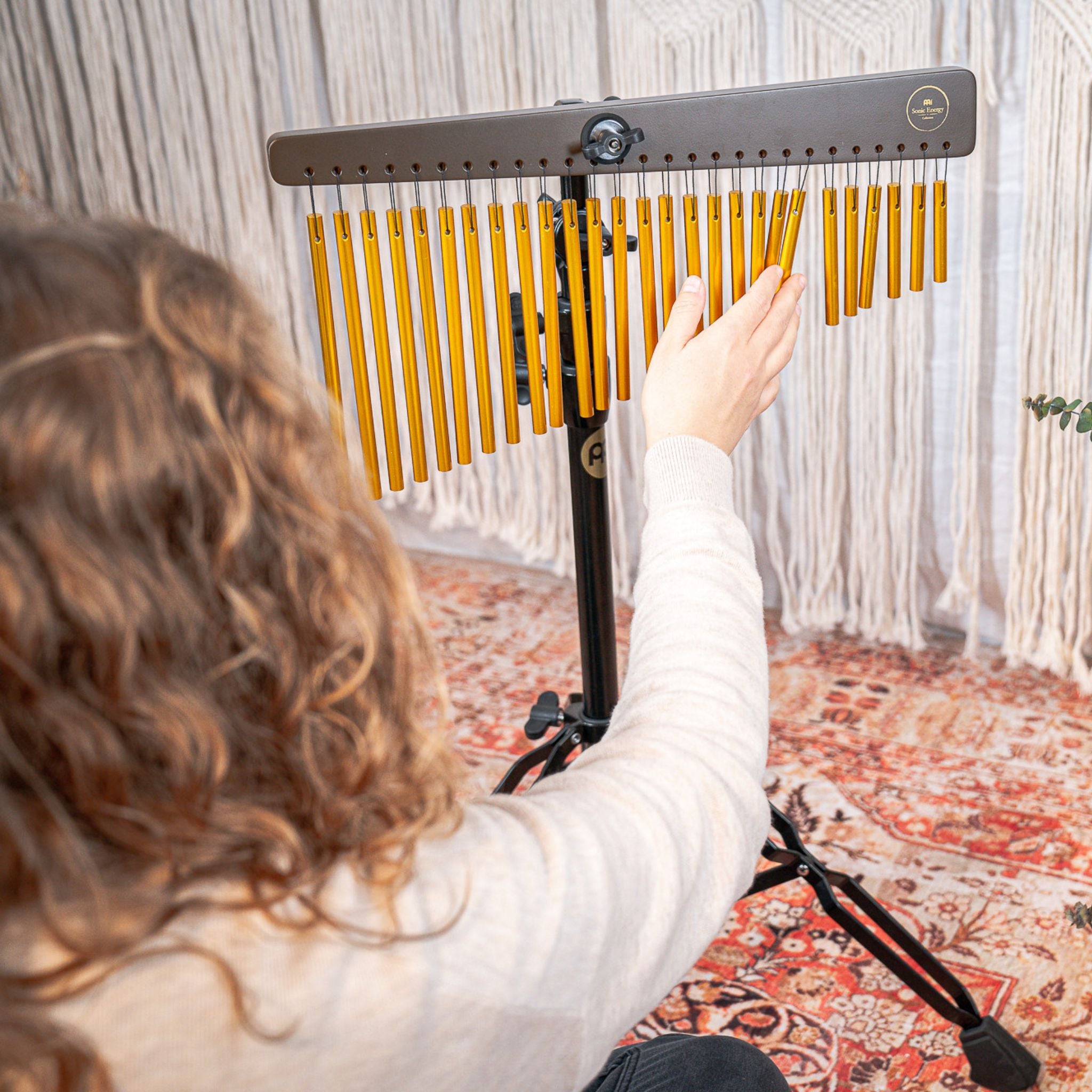 Women playing a bar chime mounted to a Meinl Energy Chimes Stand during a sound bath.