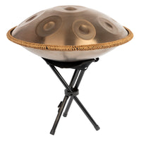 Mano Percussion ManoPan MPC69G 9-note D Kurd handpan in gold displayed on the included handpan stand.