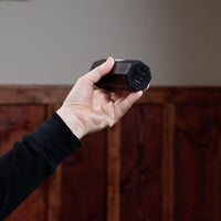 Handheld Meinl Aluminium Shaker Octagonal Small SH8BK in black, shown in a player’s hand to highlight compact size and ergonomic feel