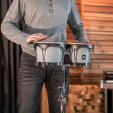 Meinl Journey Series bongo drums in Ultimate Gray (HB50UG), musician playing the bongos mounted on a stand in a studio environment.