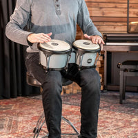 Meinl Journey Series bongo drums in Ultimate Gray (HB50UG), musician seated and playing the bongos in a studio setting.