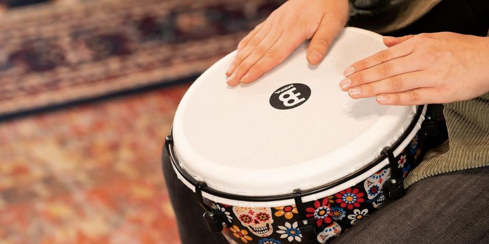 Close-up of hands playing a Meinl Day of the Dead djembe during a percussion performance session
