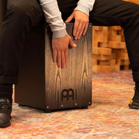 Percussionist playing the Meinl Headliner Series Snare Cajon MCAJ100BK-CBF, highlighting dynamic snare response and expressive playing control