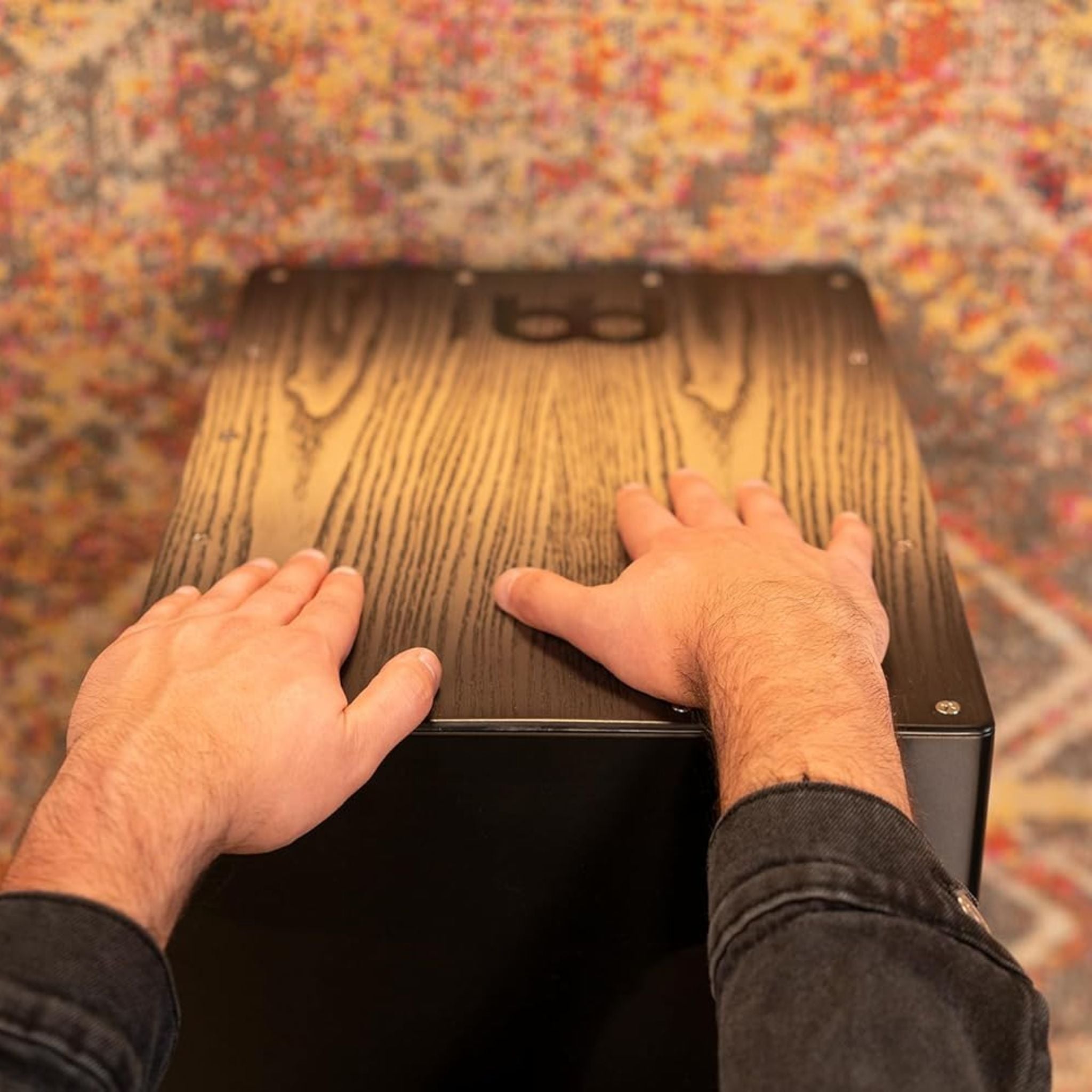 Point-of-view shot of hands playing the Meinl Headliner Series Snare Cajon MCAJ100BK-CBF, showcasing responsive playing surface and precise articulation