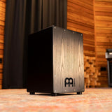 Meinl Headliner Series Snare Cajon MCAJ100BK-CBF in a rustic studio setting, highlighting its professional sound, build quality and stage-ready aesthetic