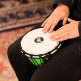 Close-up of hands playing Meinl Junior Djembe Drum 7 inch Green JRD-G showing playing surface and tone control