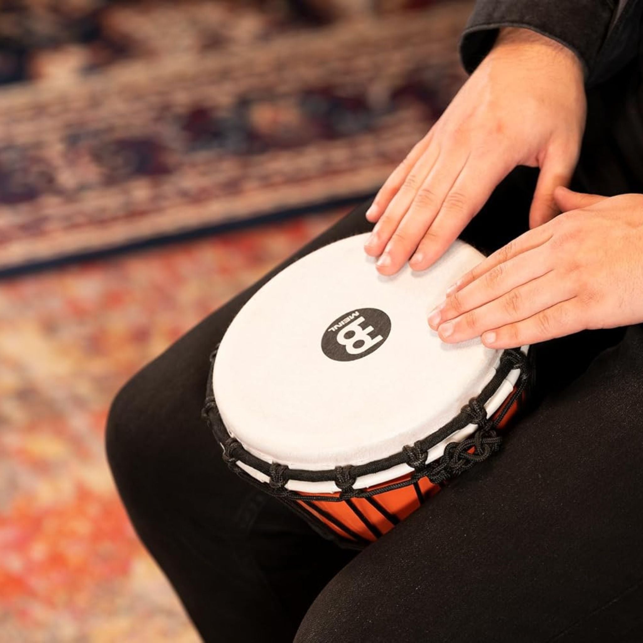 Close-up of hands playing the Meinl Junior Djembe Drum 7 inch Orange JRD-O