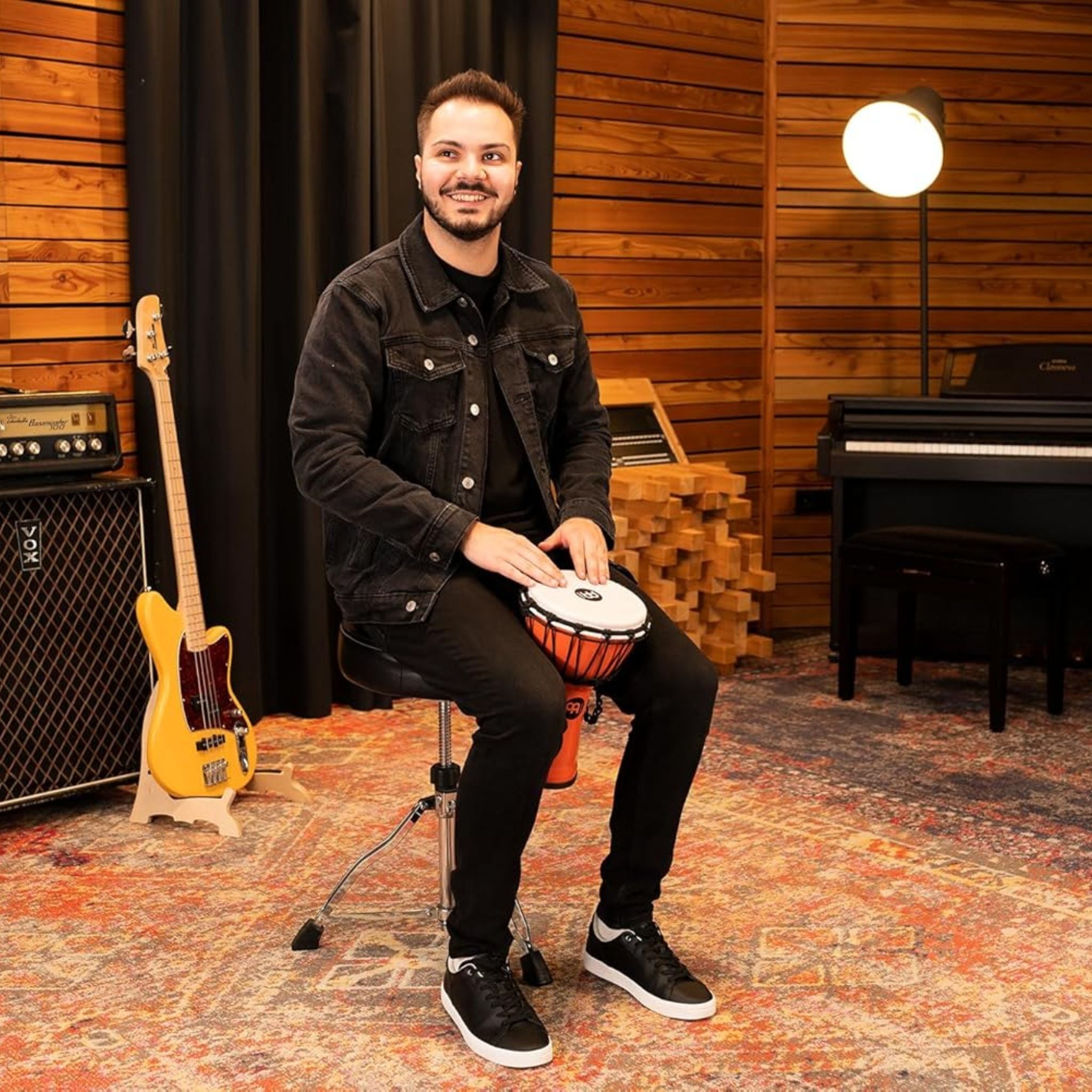 Musician playing the Meinl Junior Djembe Drum 7 inch Orange JRD-O in a studio setting