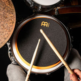 Meinl Marshmallow Practice Pad 12 inch in orange (MMP12OR), mounted on a snare drum and played with sticks, demonstrating low-volume practice within a drum kit setup.
