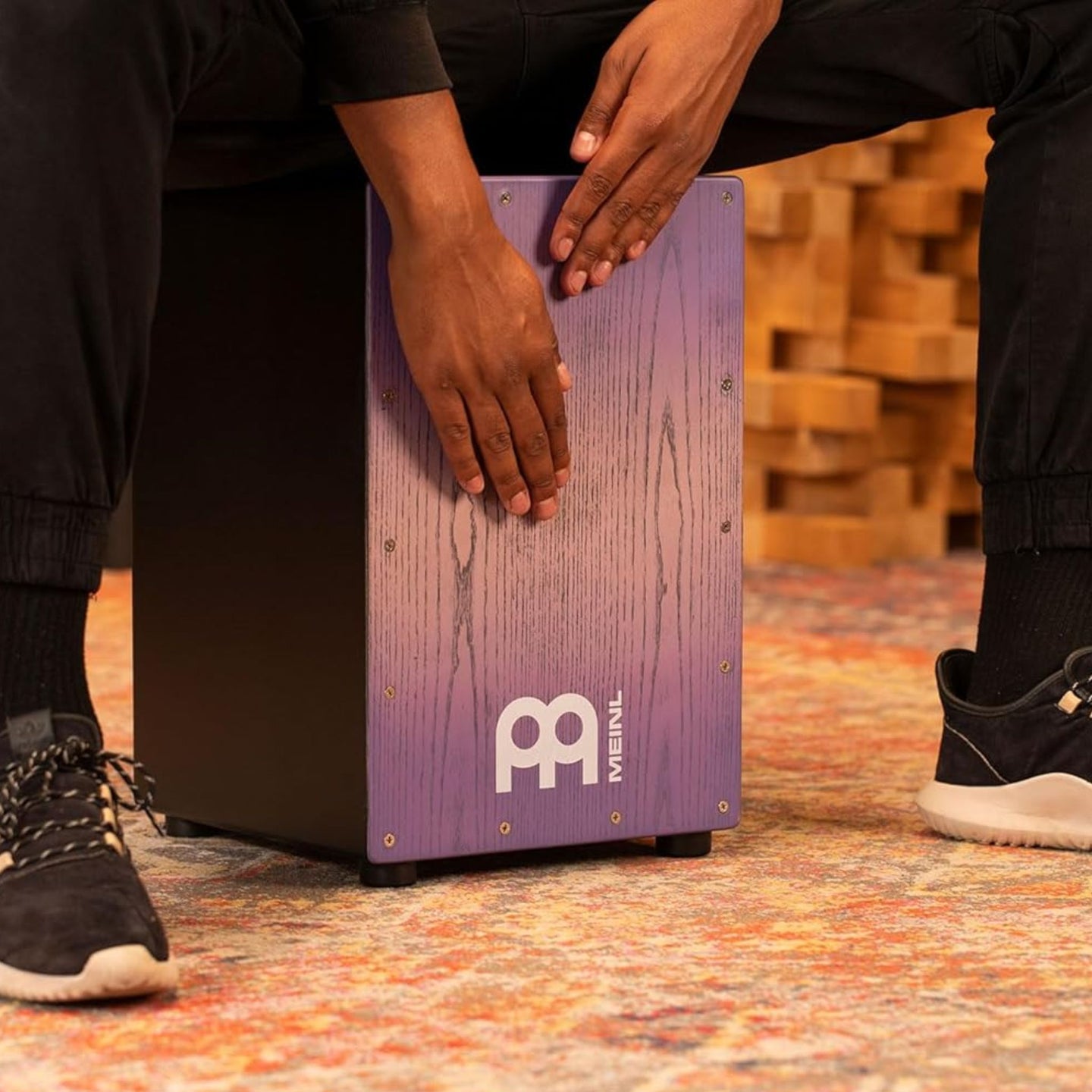 Musician playing the Meinl Snare Cajon Headliner Series Lilac Purple Fade MCAJ100BK-LPF — demonstrating professional rhythm and performance in action.
