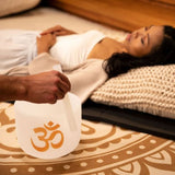 Meinl Sonic Energy 8 inch White Frosted Crystal Singing Bowl Om 136.10 Hz PCSB8OM being played with mallet during sound therapy session while participant rests nearby, demonstrating immersive quartz crystal resonance and long-lasting tones for relaxation and mindfulness practices