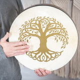 man holding Meinl Sonic Energy Frame Drum 16 inch Tree of Life HD16WB-TOL showing natural goat skin head and engraved Tree of Life symbol