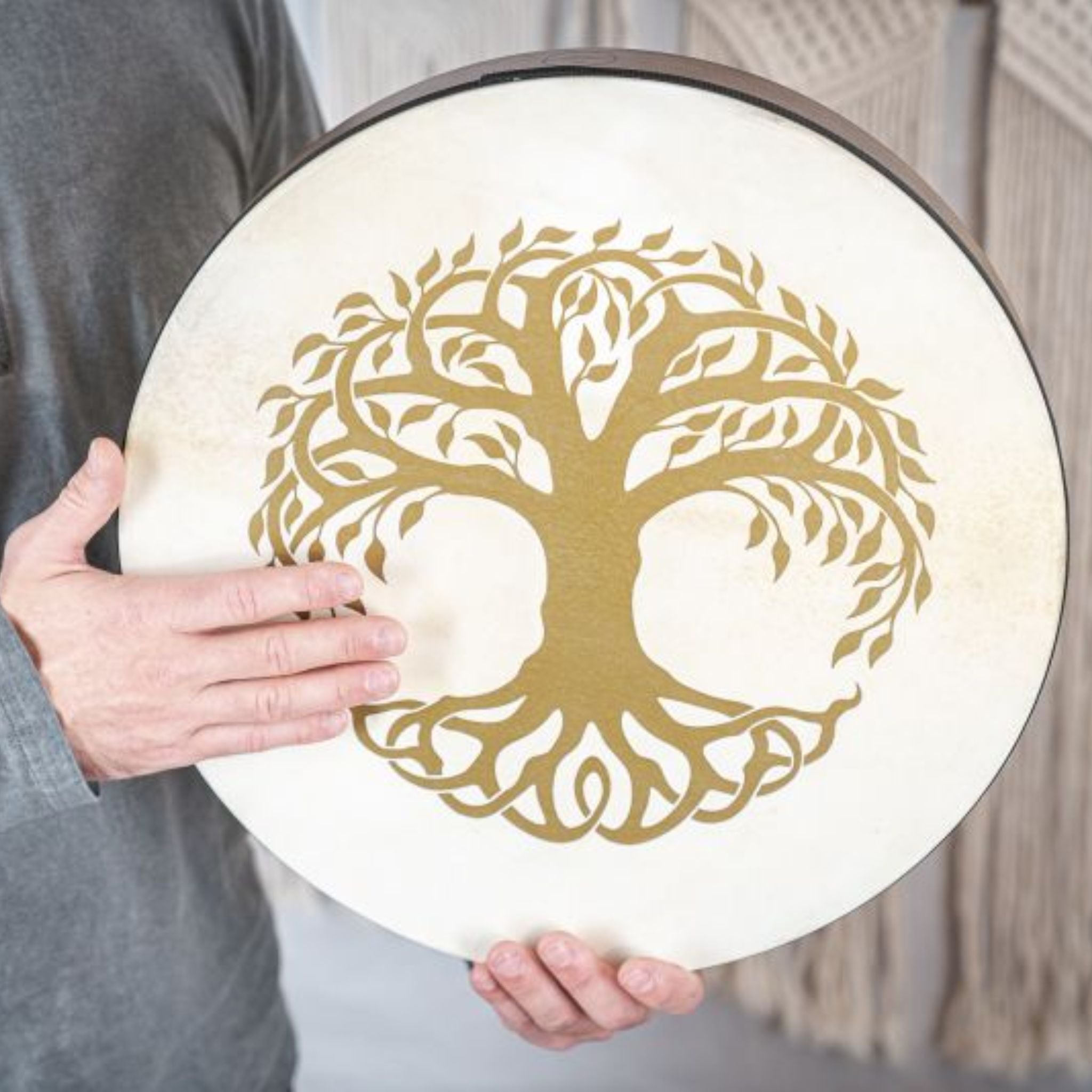 man holding Meinl Sonic Energy Frame Drum 16 inch Tree of Life HD16WB-TOL showing natural goat skin head and engraved Tree of Life symbol