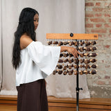 Sound healer playing Meinl Sonic Energy mixed seed chimes on a stand during a professional sound healing session