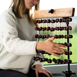 Young woman playing the Meinl Sonic Energy Pala Chimes SPCH while holding the mahogany bar with one hand.