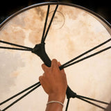 woman holding Meinl Sonic Energy Ritual Frame Drum 18 inch Goat Skin RD18WB showing rear cord cross grip and comfortable hand positioning for playing and control