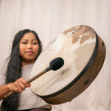 woman playing Meinl Sonic Energy Ritual Frame Drum 18 inch Goat Skin RD18WB with included mallet to create deep warm tones for meditation, sound baths, and rhythmic exploration