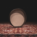 Clear drum skin side of the Meinl Sonic Energy Wave Drum 16-inch in Walnut Brown showing steel balls through the clear drumhead on a rustic mat.