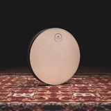 Front view of the Meinl Sonic Energy Wave Drum 16-inch in Walnut Brown featuring the natural goat-skin head resting on a rustic mat.