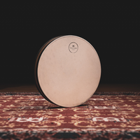 Front view of the Meinl Sonic Energy Wave Drum 16-inch in Walnut Brown featuring the natural goat-skin head resting on a rustic mat.