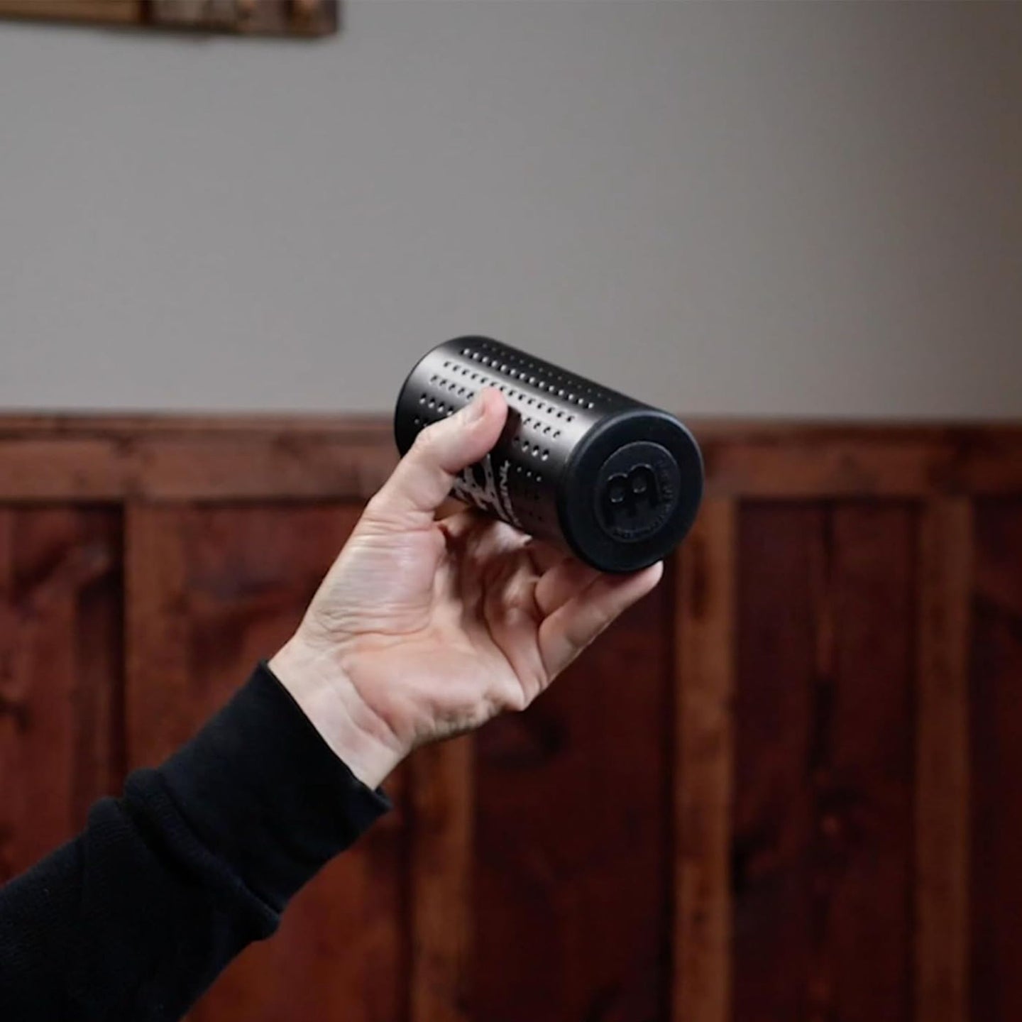 Meinl Studiomix Shaker medium volume in black (SH12-M-BK), held in hand to show compact size, ergonomic grip, and controlled studio-focused shaker design.