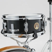 Close-up of the Tama Club-JAM Mini 12" x 5" snare drum in Charcoal Mist with part of the bass drum and hi-hat stand visible.